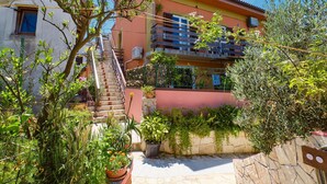 A multi-story building with a staircase leading to the upper floors. - Apartment Blamax (Mali Losinj)