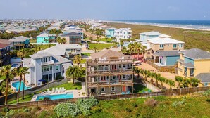 A coastal residential area with multiple two-story houses, a swimming pool, and a beach view.