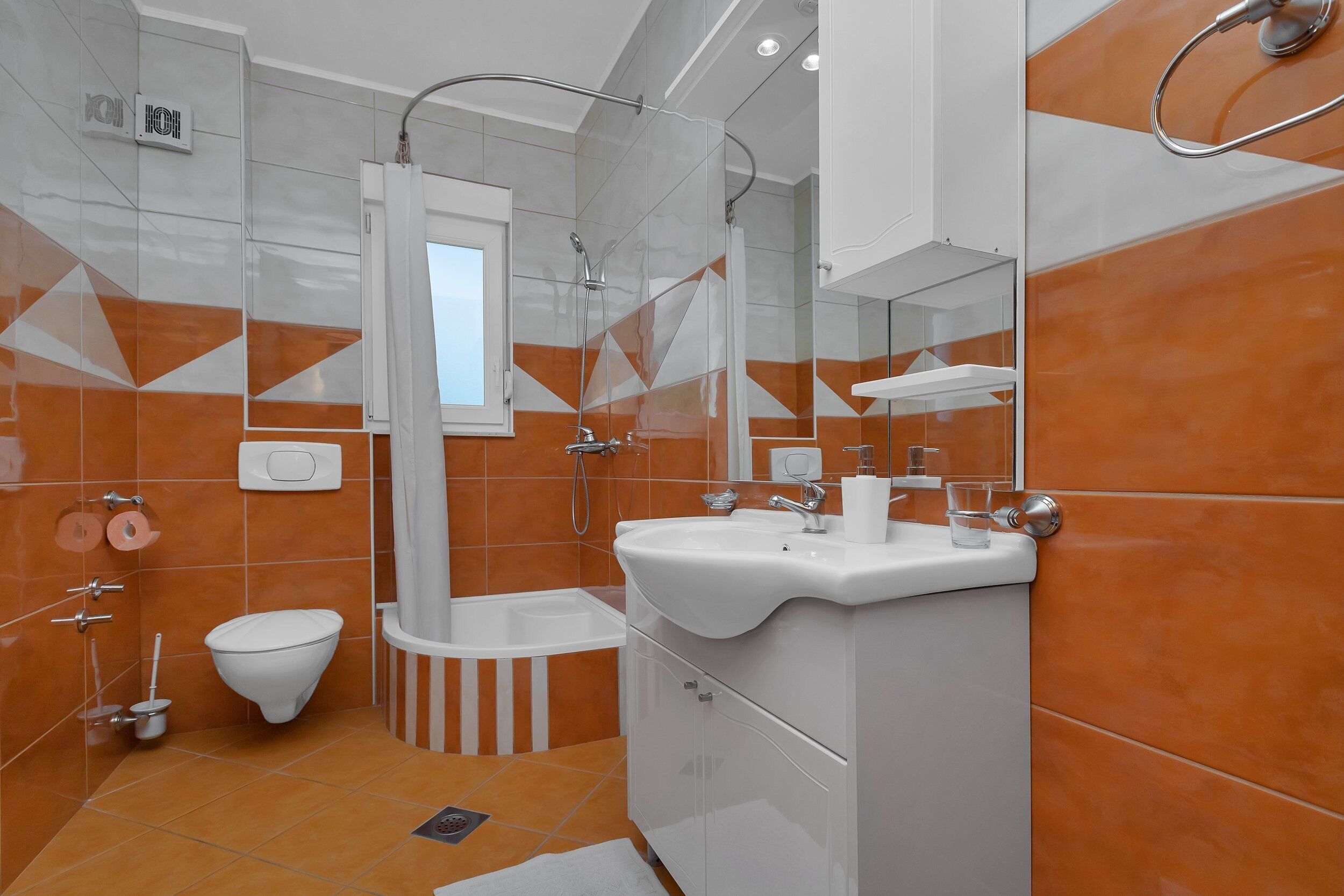 Une salle de bain moderne équipée d’une douche, de toilettes et d’un lavabo.