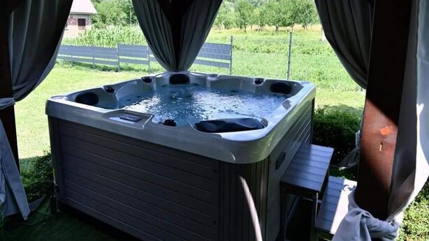 A hot tub under a covered area with a view of a grassy field and trees. - Tetina Kuća (Saborsko)