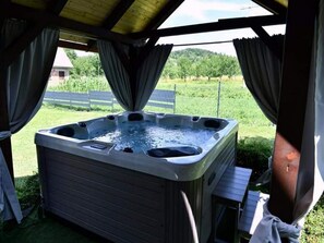 A hot tub under a covered area with a view of a grassy field and trees. - Tetina Kuća (Saborsko)