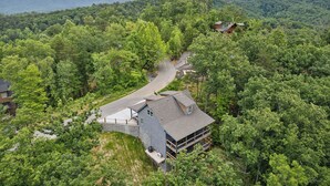 A house surrounded by dense forest with a winding road leading to it. - Luxury Cabin|Indoor Pool|Hot Tub|Ping Pong (Sevierville)
