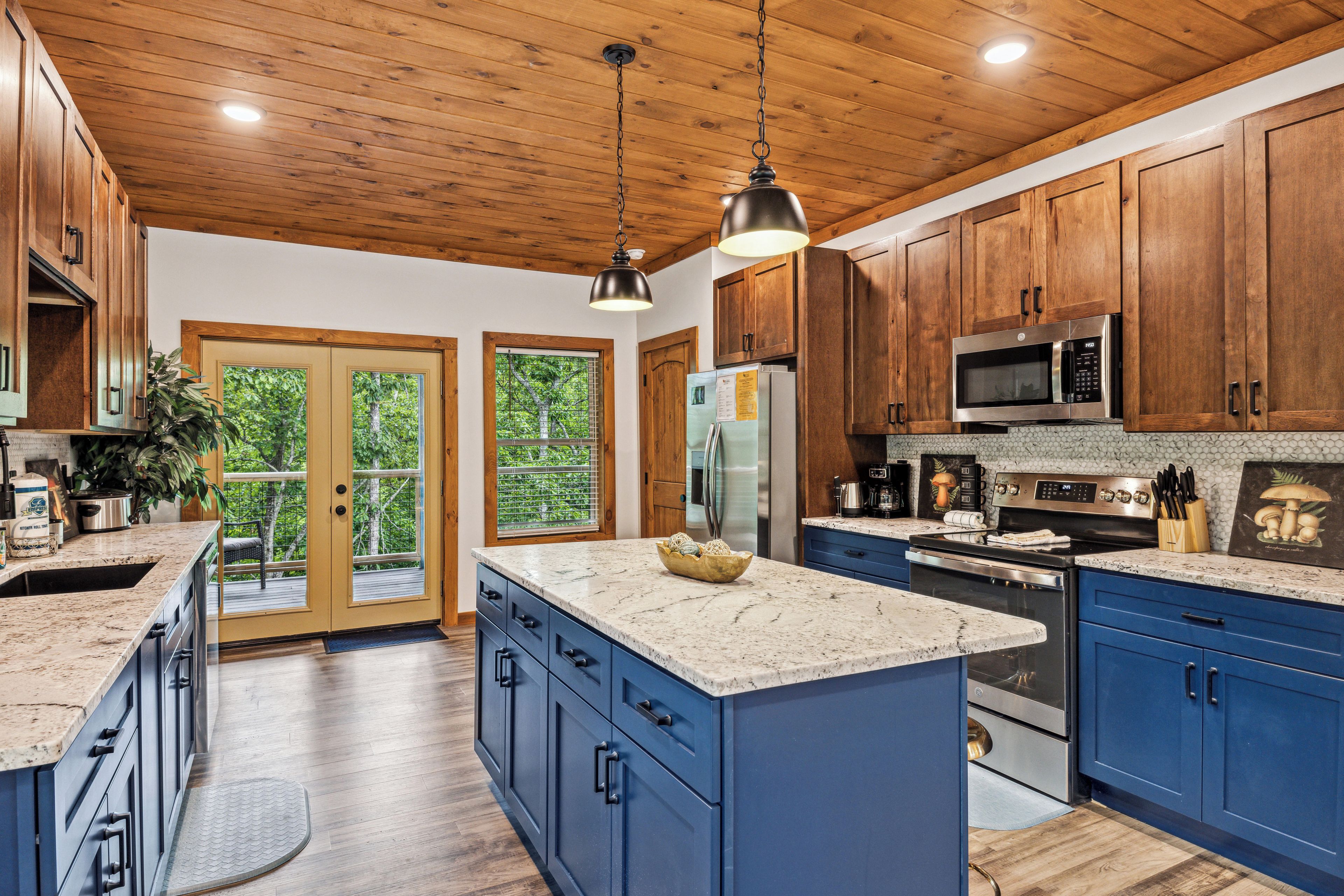 A spacious kitchen with wooden cabinets, granite countertops, stainless steel appliances, and a large island.