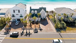 Zona residencial costera con casas, una playa y cielo despejado.
