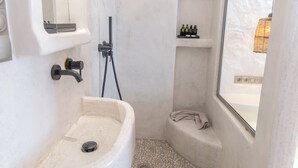 A bathroom with a freestanding sink, a shower, and a window. - Nikos Apartments & Studios (Naxos)