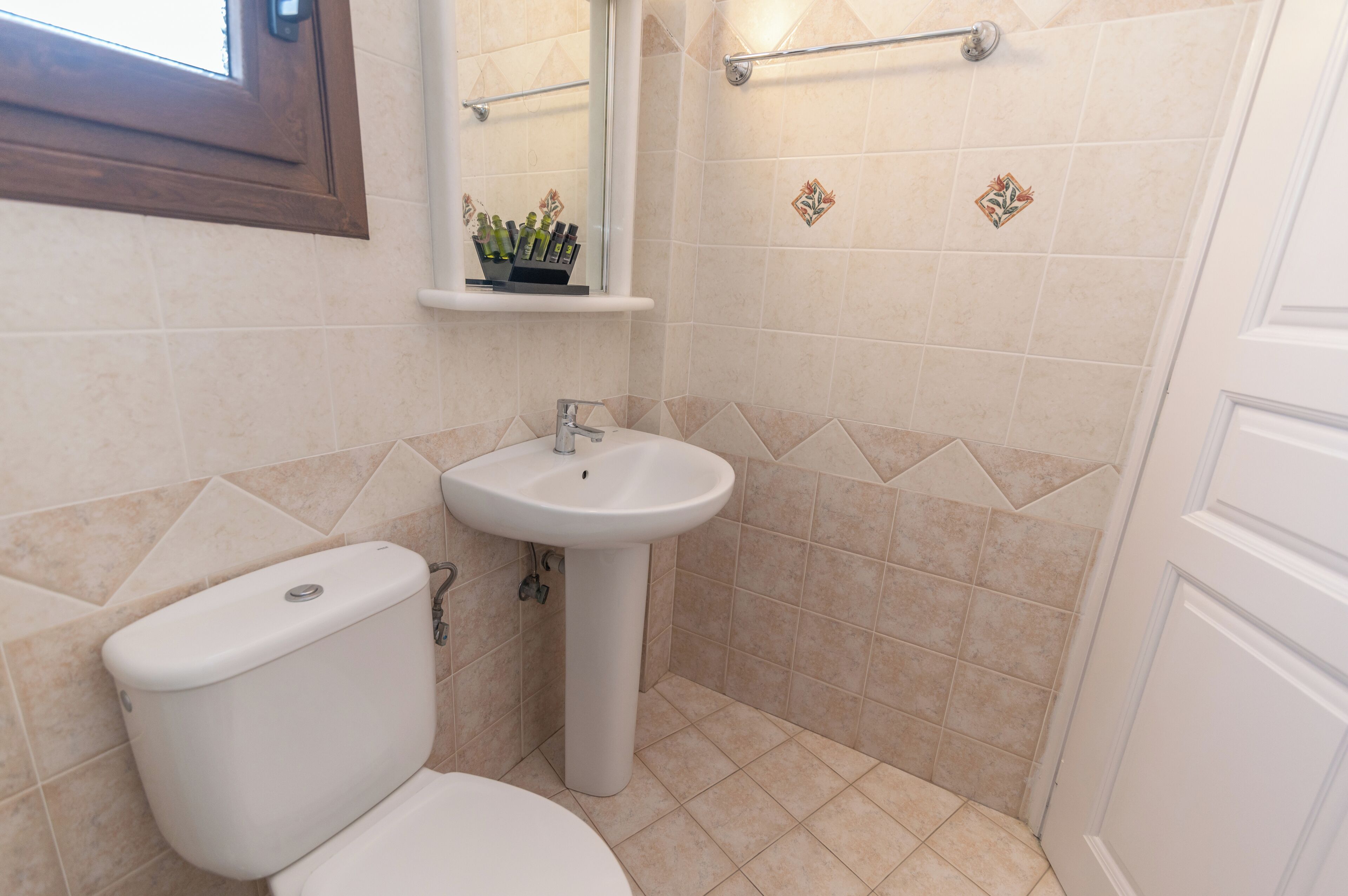 A bathroom with a toilet, sink, and shower area.