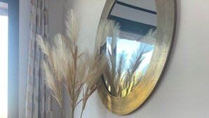 A wooden console table with a vase of pampas grass and a decorative mirror. - Cozy villa between sea and mountains (Figari)