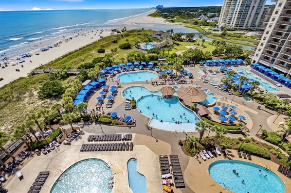 A resort with multiple swimming pools, beach access, and a view of the ocean.
