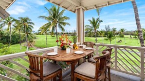A covered outdoor dining area with a view of a golf course.