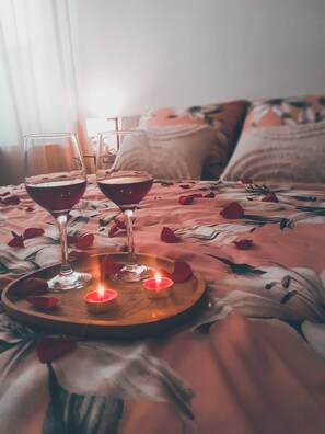 Relax in a serene bedroom with a plush bed, complete with a floral-patterned bedspread and a bedside tray.