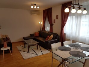 Relax in this stylish living room with a sofa, coffee table, and dining area.