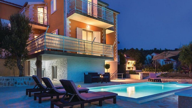 A two-story building with a swimming pool, lounge chairs, and outdoor furniture. - Apartment Niko (Sibenik)