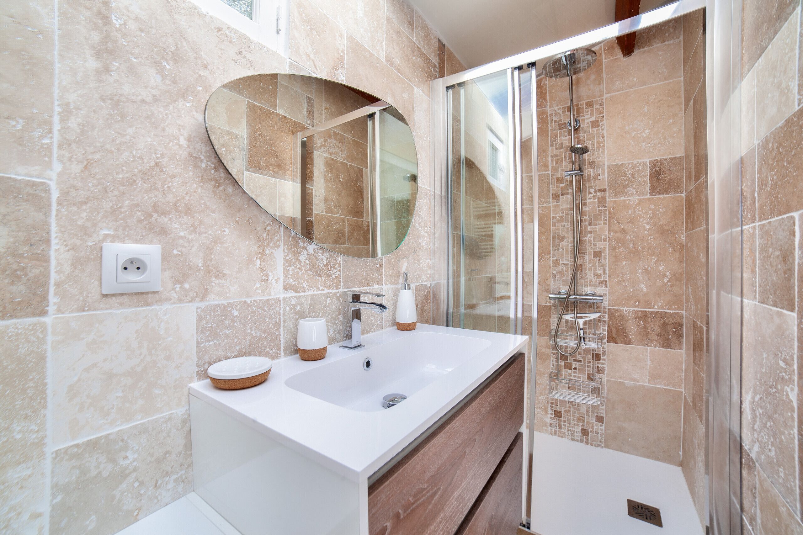 A modern bathroom with a large sink, a mirror, and a shower.