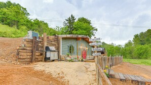 A rustic building with a dirt path leading to it, surrounded by greenery. - Magical 2BR Hobbit Themed House Near Gatlinburg (Cosby)