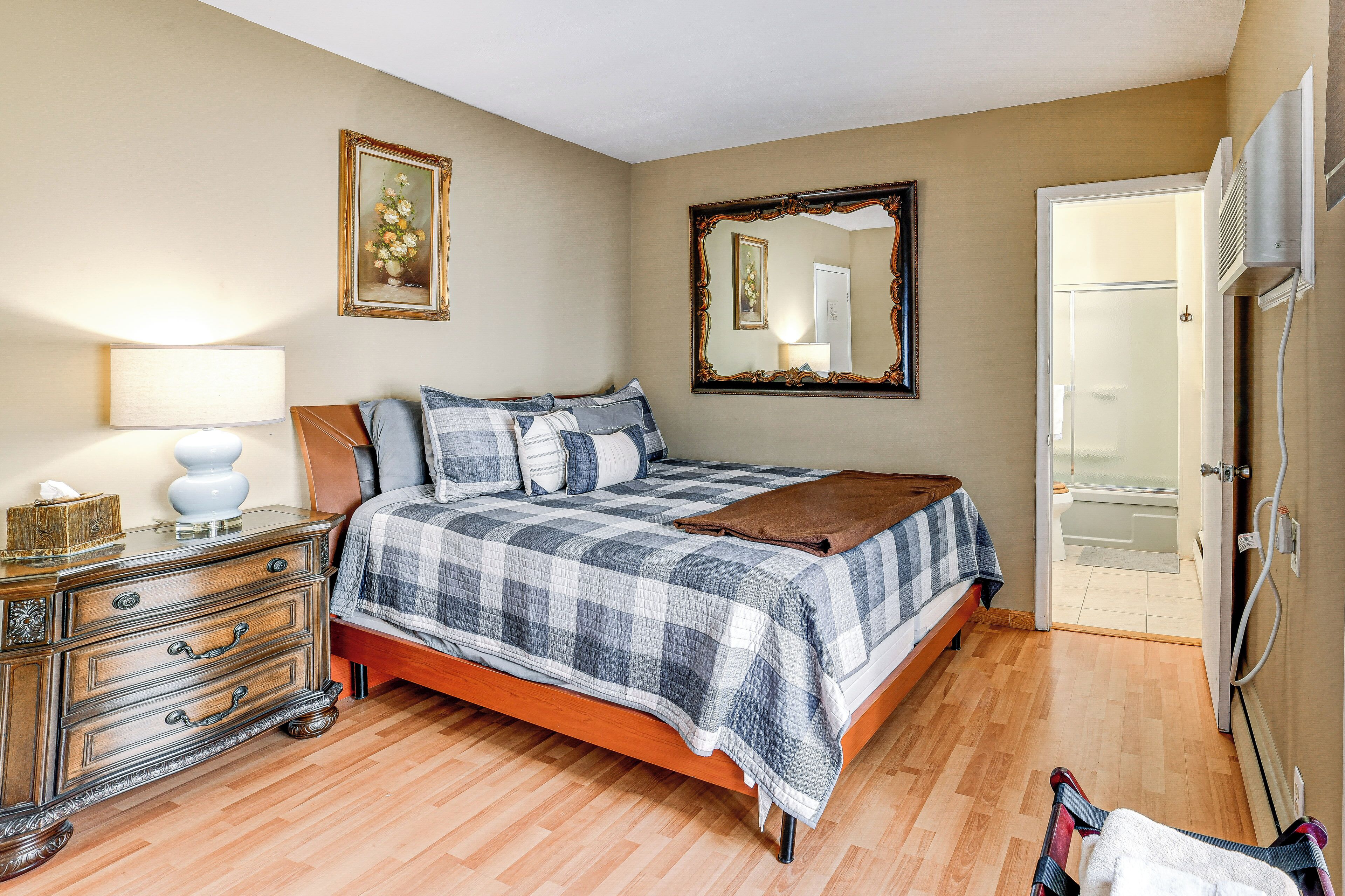 A bedroom with a bed, dresser, mirror, and a door leading to a balcony.