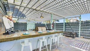 An outdoor bar area with a high ceiling, a chef statue, and a stone countertop. - Bar & Fire Pit: Pet-friendly Phoenix 'La Casita' (Phoenix)