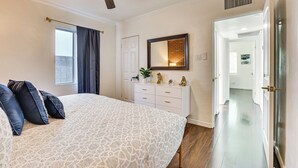 A bedroom with a bed, a ceiling fan, a dresser, and a door leading to another room. - Bar & Fire Pit: Pet-friendly Phoenix 'La Casita' (Phoenix)