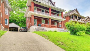 A two-story brick house with a front porch, a garage, and a driveway. - Pet-friendly Cincinnati Apt: 5 Mi to Downtown! (Cincinnati)
