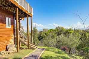 A wooden cabin with a wooden deck and stairs leading to a balcony. - Sevierville Home w/ Mountain & Countryside Views (Sevierville)