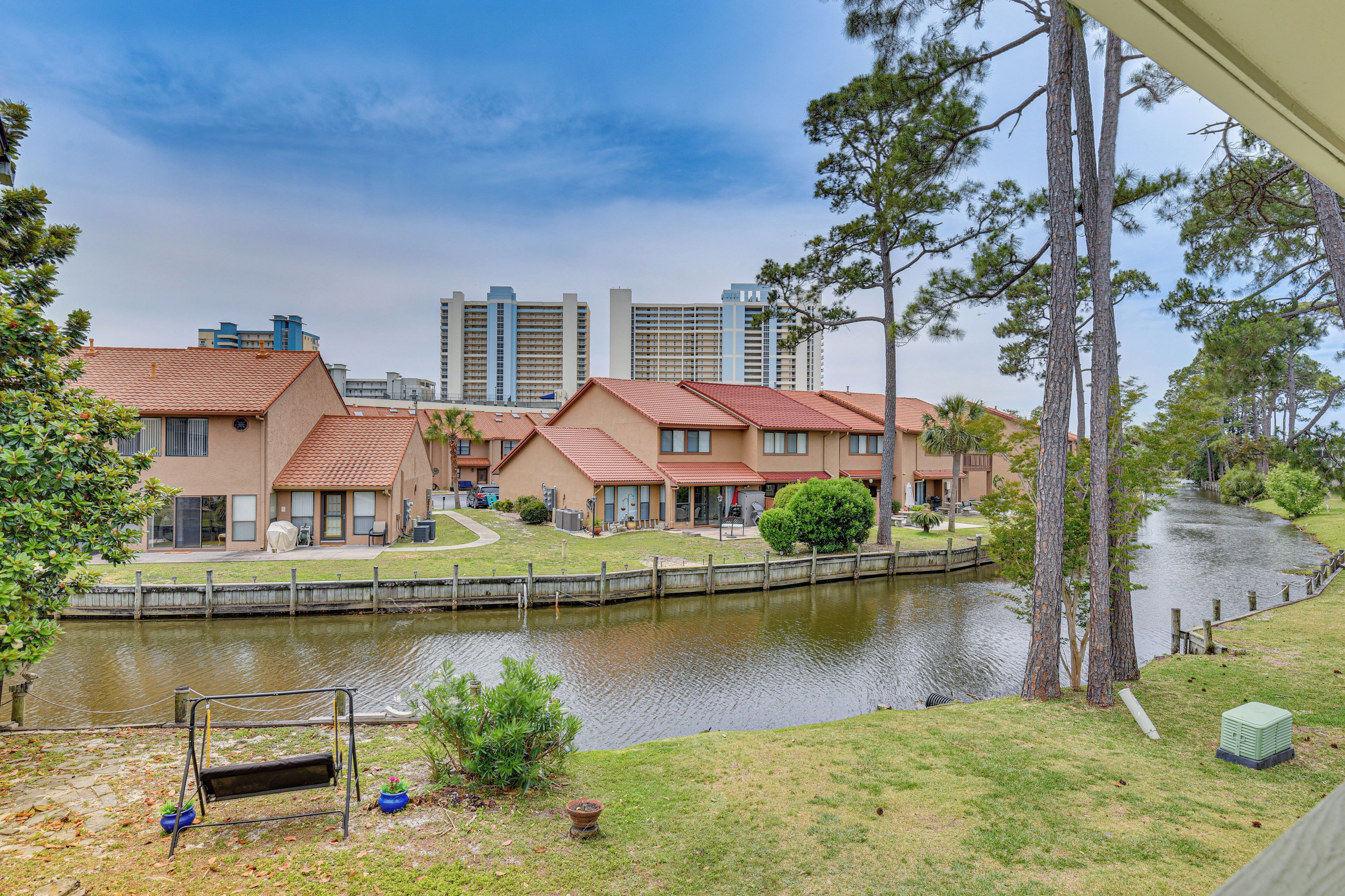 Un barrio residencial con casas a lo largo de un canal, un columpio y un pequeño jardín.