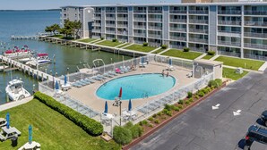 A hotel with a swimming pool, a marina with boats, and a view of the water.