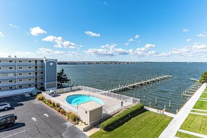 Ein Hotel mit Schwimmbad, einer Anlegestelle im Wasser und Blick auf das Wasser sowie die entfernte Küste.