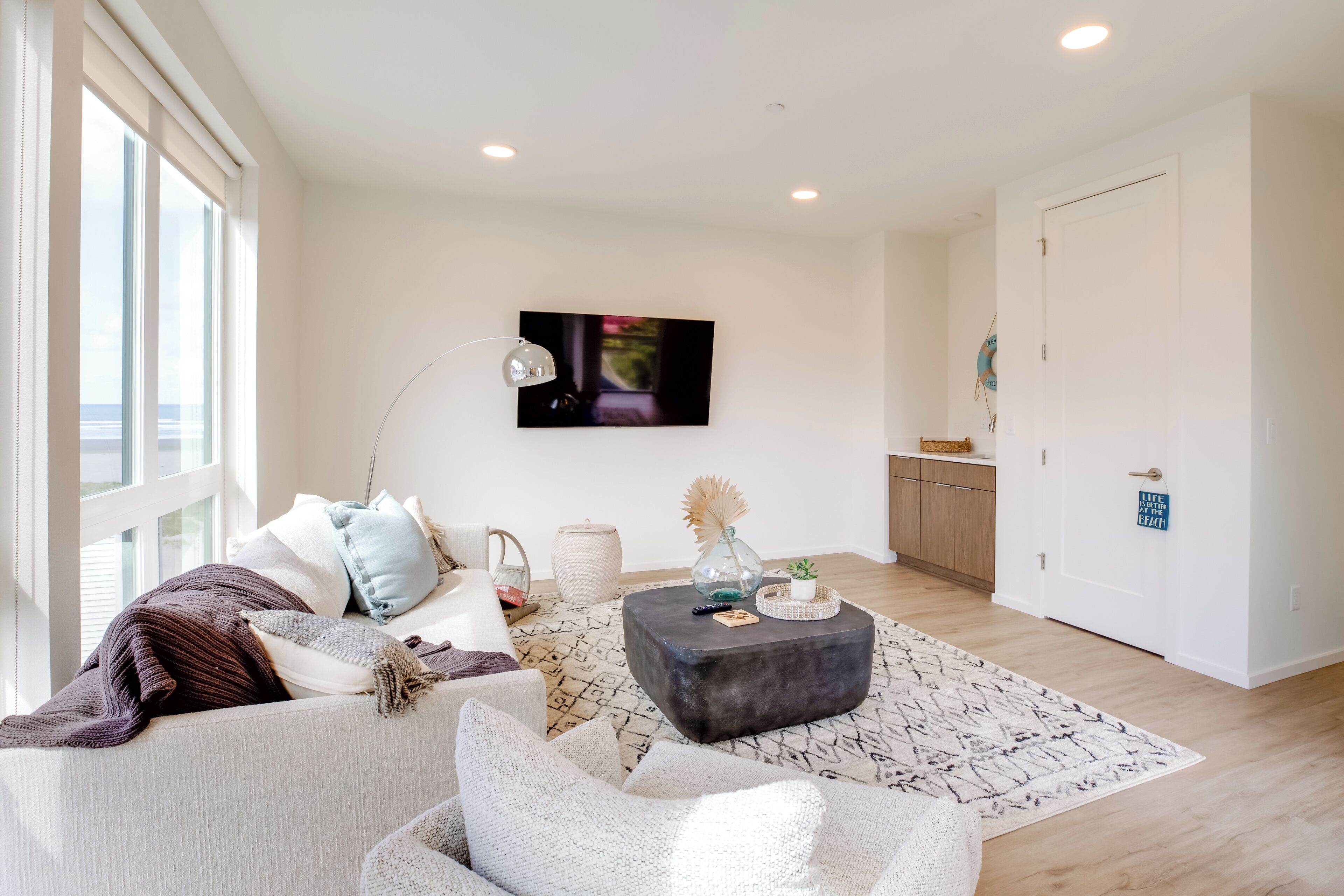 A modern living room with a sofa, a coffee table, and a television.