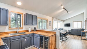 Una cucina moderna con mobili scuri, un piano di lavoro in legno e un frigorifero integrato.