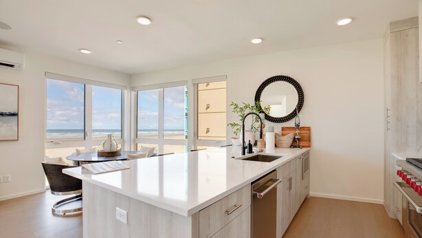 Una cocina moderna con una isla grande, horno empotrado y vistas al exterior.