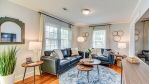 Un salon moderne avec un canapé d’angle, une table basse ronde et un grand tapis.