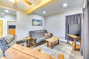 Uma sala de estar com sofá, mesa de centro e televisão.