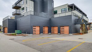Un edificio moderno de varios pisos, con amplias puertas de garaje y una escalera que lleva a un nivel superior.