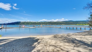 A lakeside view with a dock extending into the water, surrounded by trees and hills in the background. - Harrison Home w/ Grill & Lake Views: Walk to Town! (Harrison)