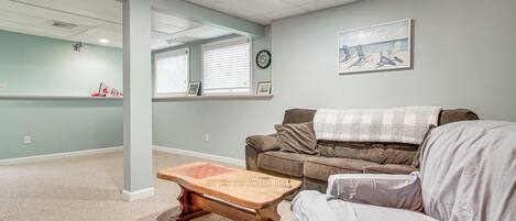 A living room with a brown sofa, a wooden coffee table, and a light blue wall.