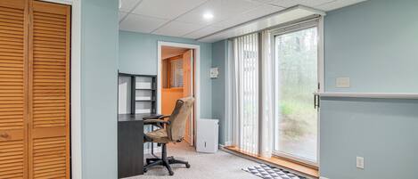 A room with a desk, chair, and a sliding door closet.