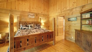 A wooden cabin-style bedroom with a wooden bed, a nightstand, a bookshelf, and a sign reading "Hibernation Station." - Winter Hiking + Hot Tub Soaks! Marion Mtn Cabin (Marion)