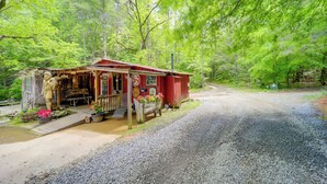A rustic cabin with a porch, surrounded by lush greenery and a gravel driveway. - Hot Tub Haven! Blue Ridge Mountain Gem on 92 Acres (Marion)