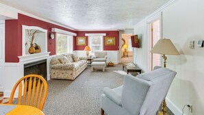 A living room with a fireplace, a sofa, a chair, and a lamp. - Relax Fireside! Frankfort Apt Near Dtwn & Beaches (Frankfort)