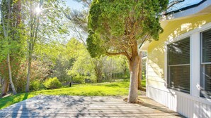 A wooden deck leading to a house with a large tree in the center. - Relax Fireside! Frankfort Apt Near Dtwn & Beaches (Frankfort)