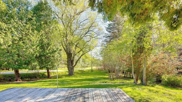 A wooden deck with a grassy area and trees. - Relax Fireside! Frankfort Apt Near Dtwn & Beaches (Frankfort)