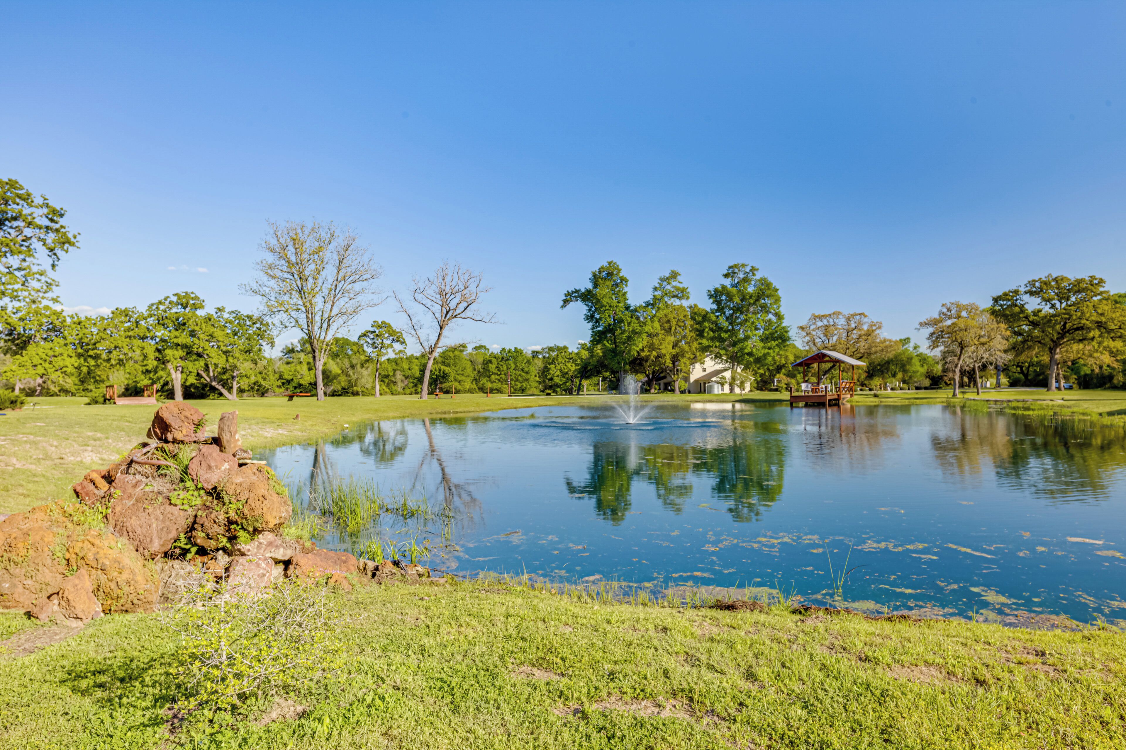 Un lac paisible, agrémenté d’un belvédère, entouré d’une végétation luxuriante et d’arbres.