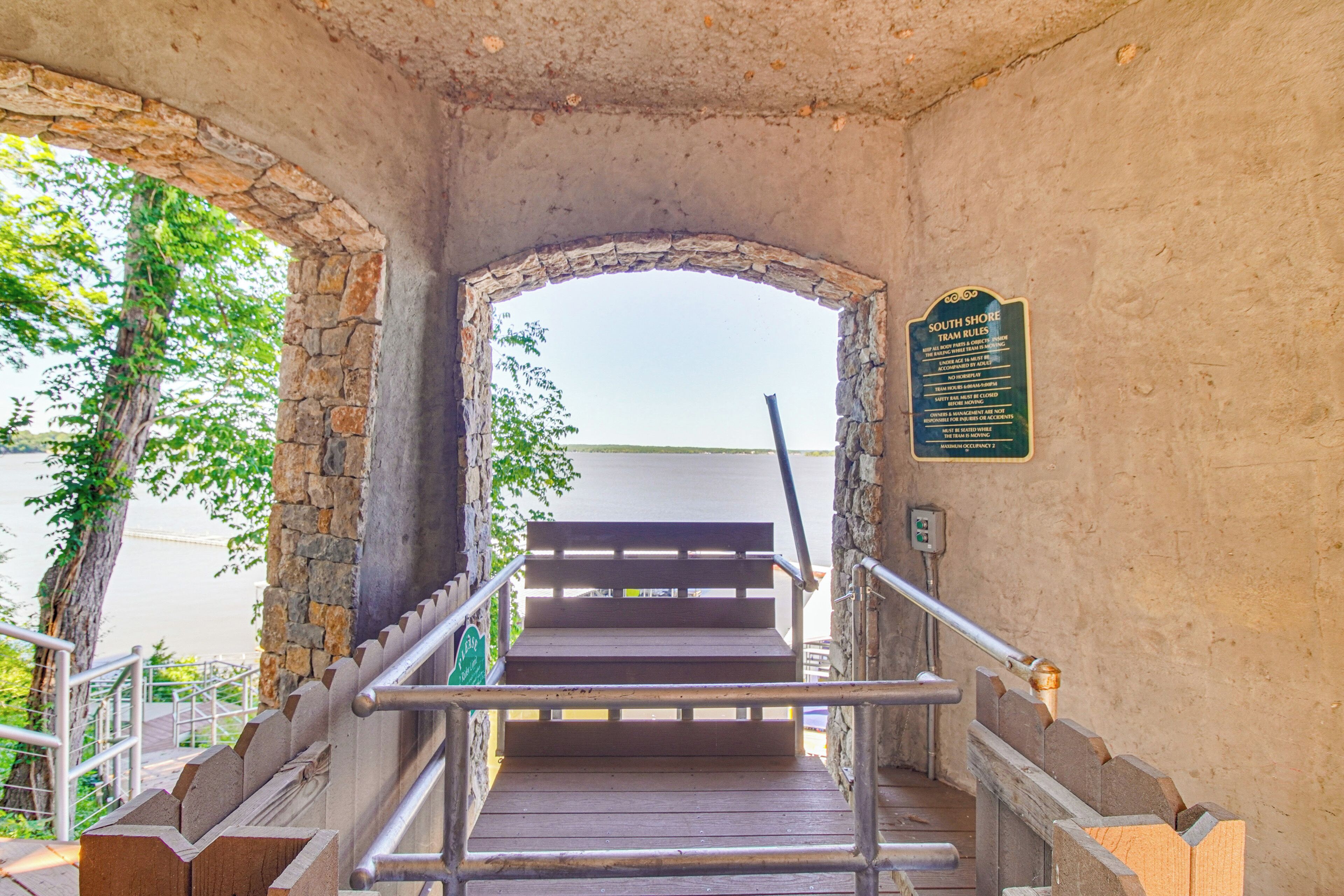 Eine Treppe führt zu einer höheren Ebene, mit einem steinernen Bogen und einem Schild, das 'South Shore Town Rules' anzeigt.