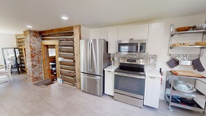 A modern kitchen with stainless steel appliances, a microwave, and a built-in oven. - Rustic & Refined - Gunnison (Gunnison)
