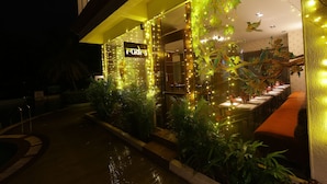 A restaurant with outdoor seating, string lights, and a sign that reads "rudra." - Kailash Parbat (Mawal)