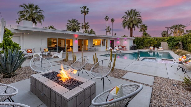 A modern outdoor living area with a fire pit, lounge chairs, and a pool. - Desert Bloom Retreat - Upscale Mid-Mod Home! (Palm Springs)