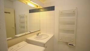 A bathroom with a white sink, mirror, and towel rack. - Studio for 4 with marina view (Canet-en-Roussillon)