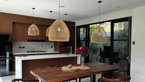 Una cocina moderna con armarios de madera, una isla central e iluminación colgante.