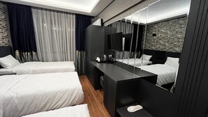 Une chambre d’hôtel moderne avec deux lits, un grand miroir et un plancher en bois.