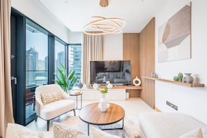 A modern living room with a large TV, a coffee table, and a sofa.