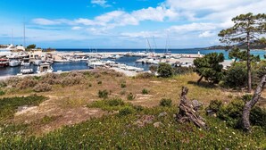 A marina with boats docked, a clear sky, and a coastal landscape. - Casa Maza Corta by Interhome (Lumio)